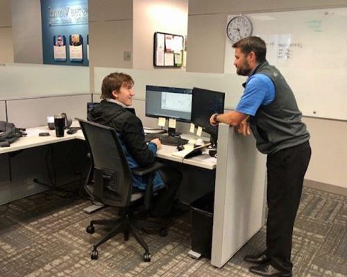 Two 澳门足彩app employees talking in the 达拉斯 office